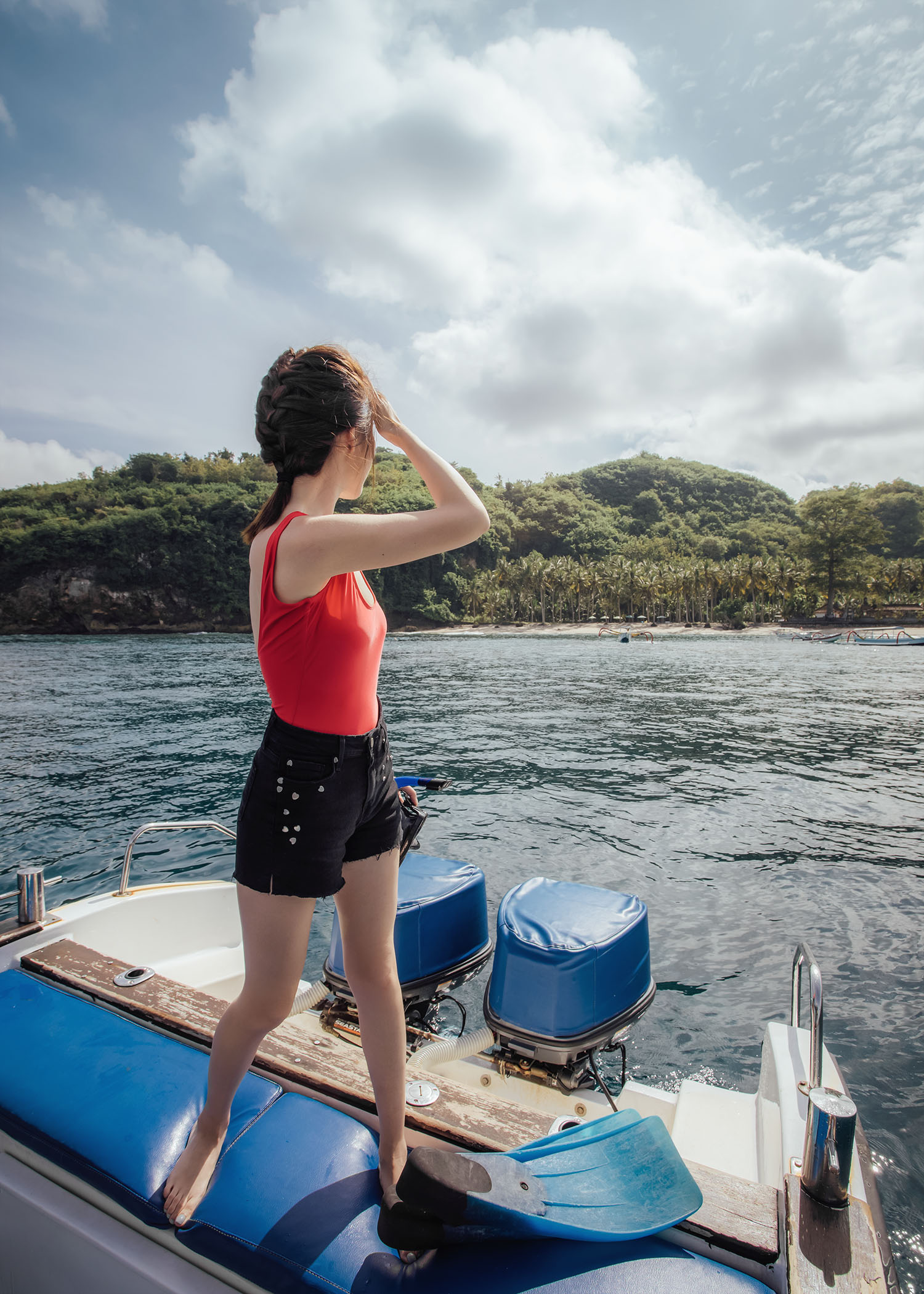 Fashion and travel blogger influencer Jenny Tsang of Tsangtastic traveling in Bali, Indonesia, wearing COVER Tank Swimsuit, PAIGE Heart Shorts, while snorkeling.