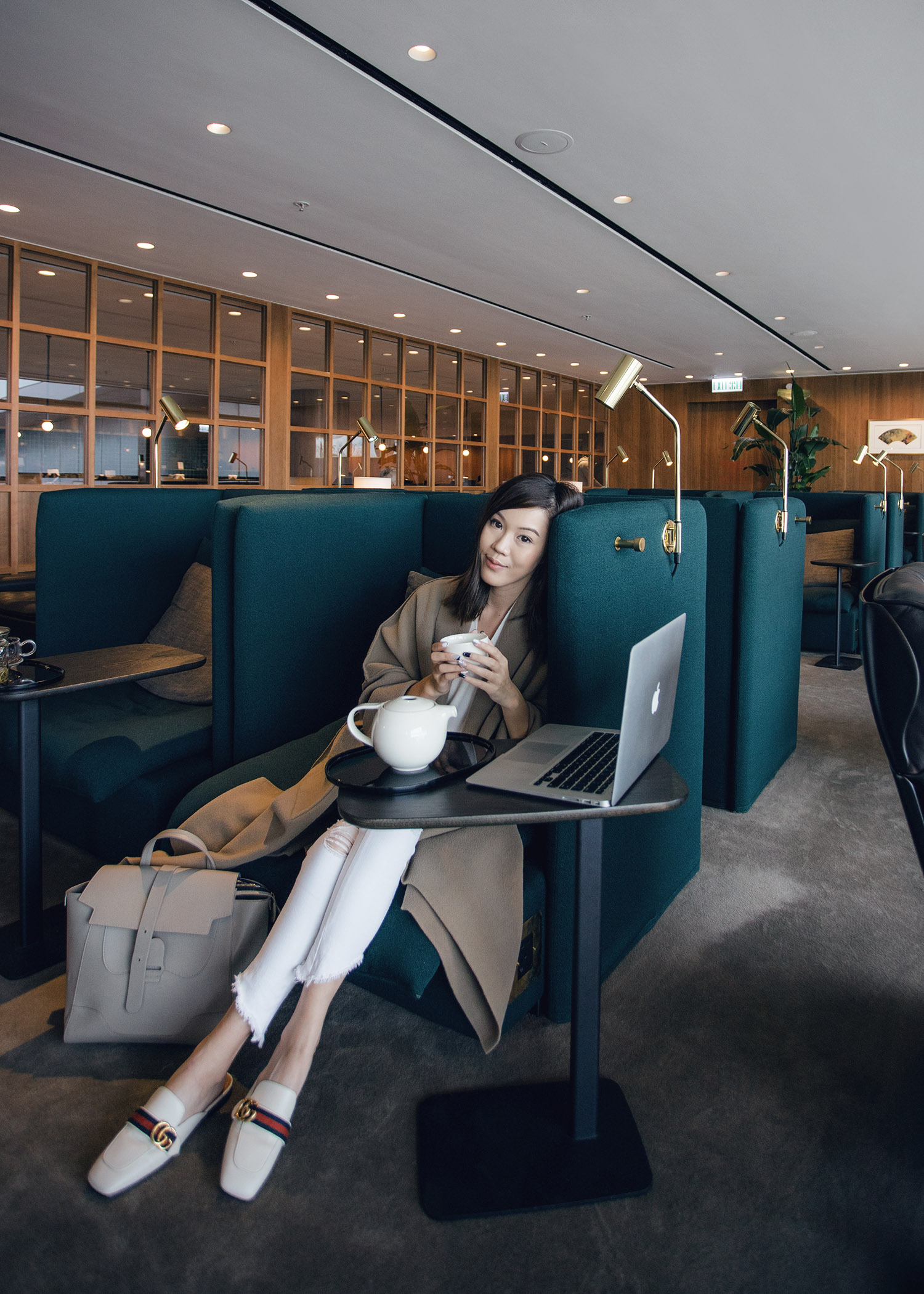 Fashion and travel blogger influencer Jenny Tsang of Tsangtastic traveling in Hong Kong, with Cathay Pacific, wearing Vince Cashmere Sweater and Gucci White Leather Slipper.