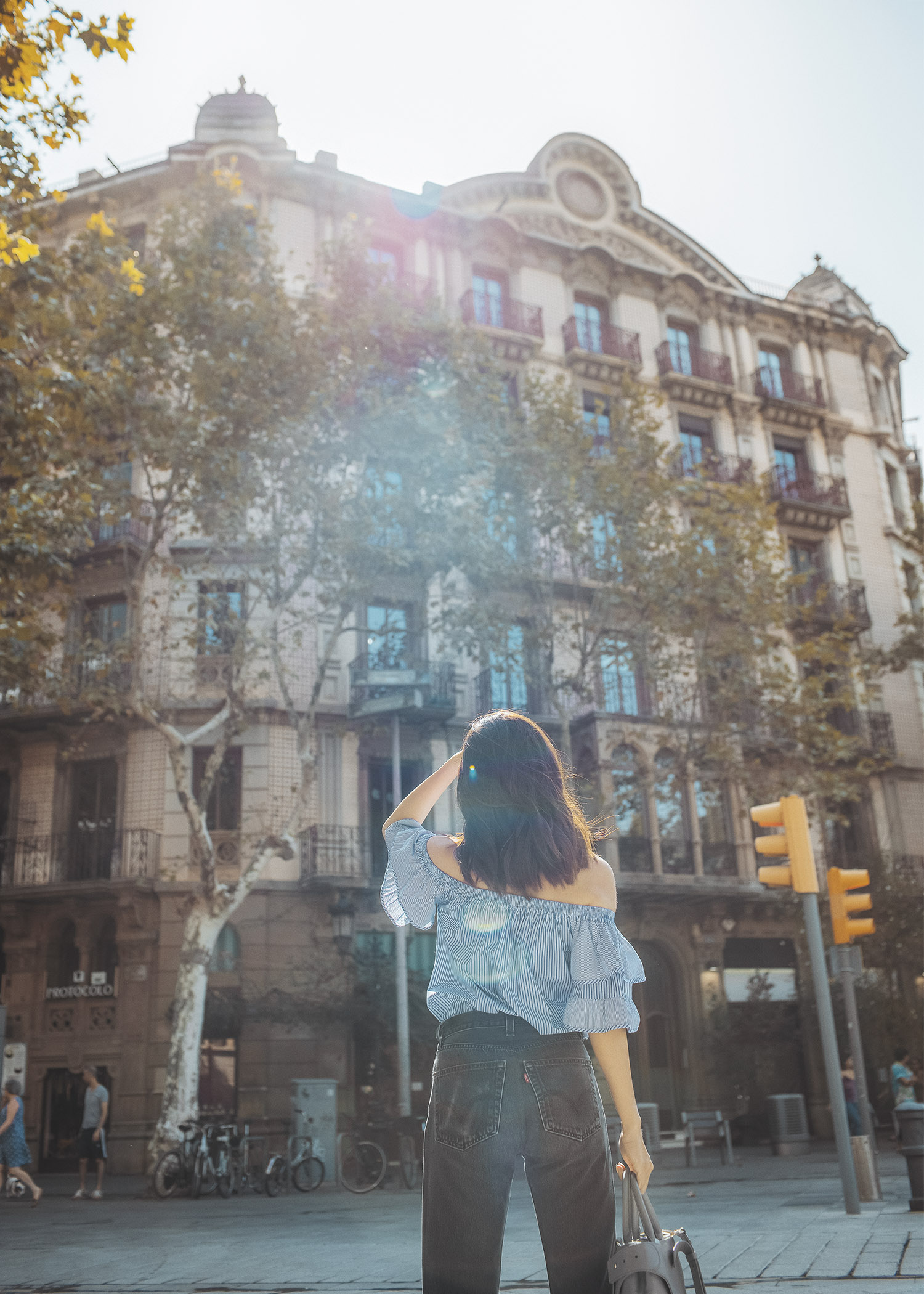 Lifestyle fashion travel blogger Jenny Tsang of Tsangtastic wearing off shoulder ruffle sleeve top and re/done levis jeans and roger vivier leather bag in Barcelona Spain.