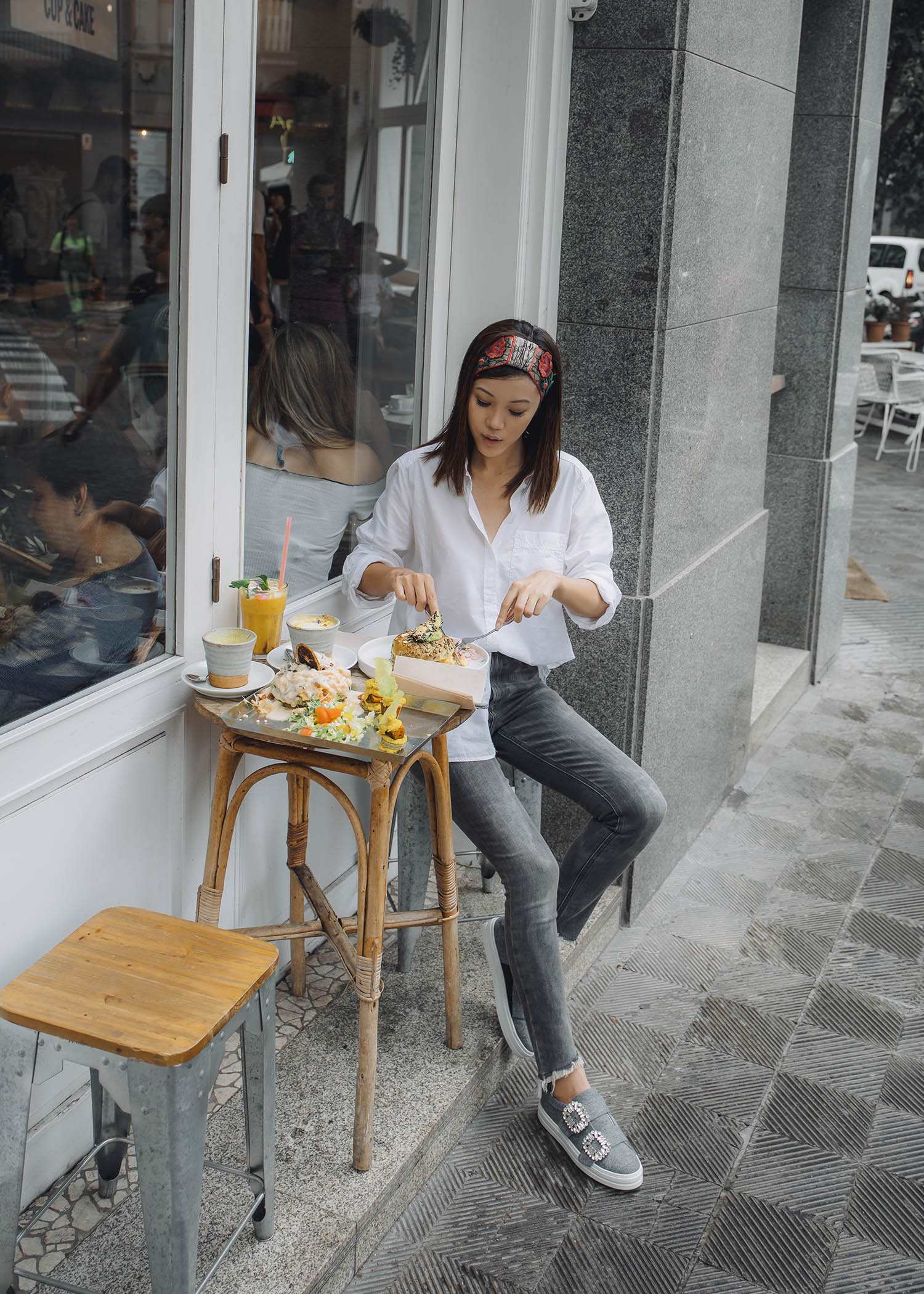 Lifestyle fashion travel blogger Jenny Tsang of Tsangtastic wearing off Gucci headband white button down shirt grey raw hem skinny jeans and roger vivier grey sneakers in Barcelona Spain