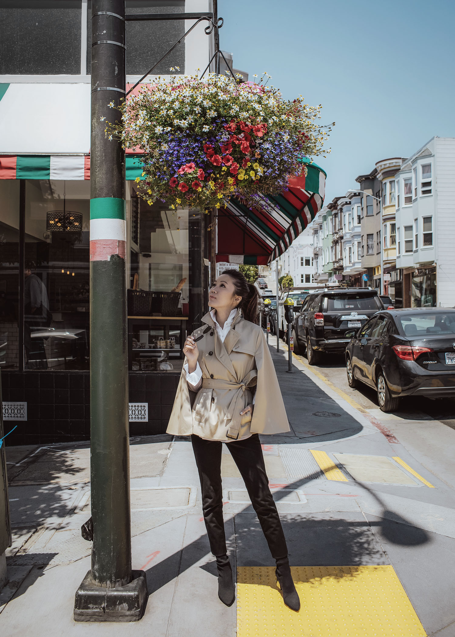 Street style fashion blogger influencer Jenny Tsang of Tsangtastic wearing trench cape white shirt black straight pant sock boots in San Francisco California 