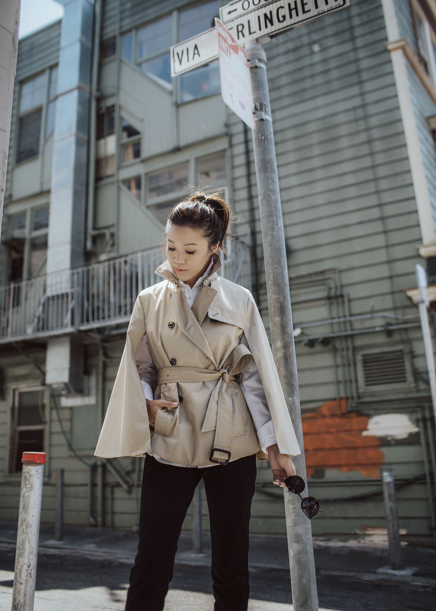 Street style fashion blogger influencer Jenny Tsang of Tsangtastic wearing trench cape white shirt black straight pant sock boots in San Francisco California 