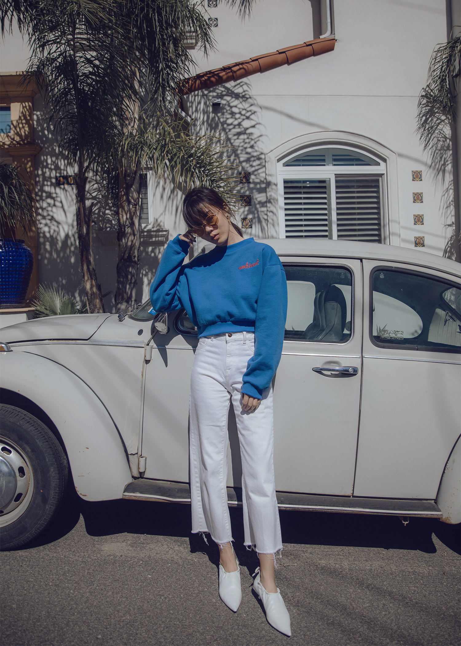 Cropped sweatshirt with high-waisted white jeans white pointed heels