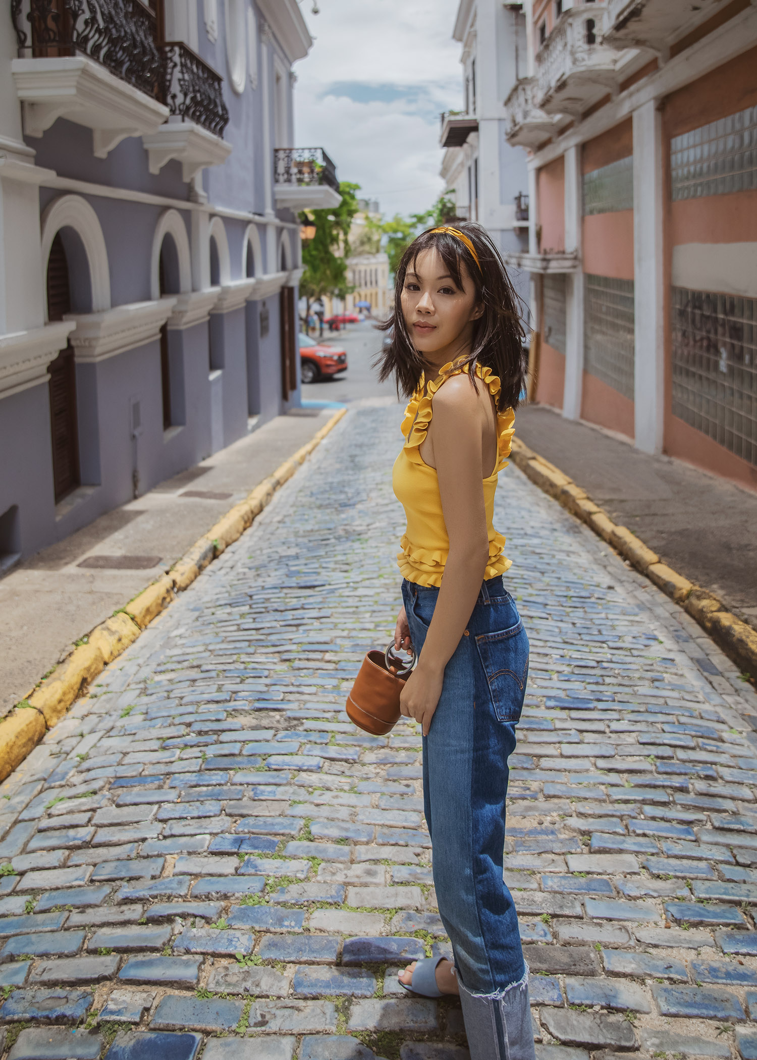 Jenny of Tsangtastic in Puerto Rico wearing yellow tank style ruffle trim top re/done cuffed jeans