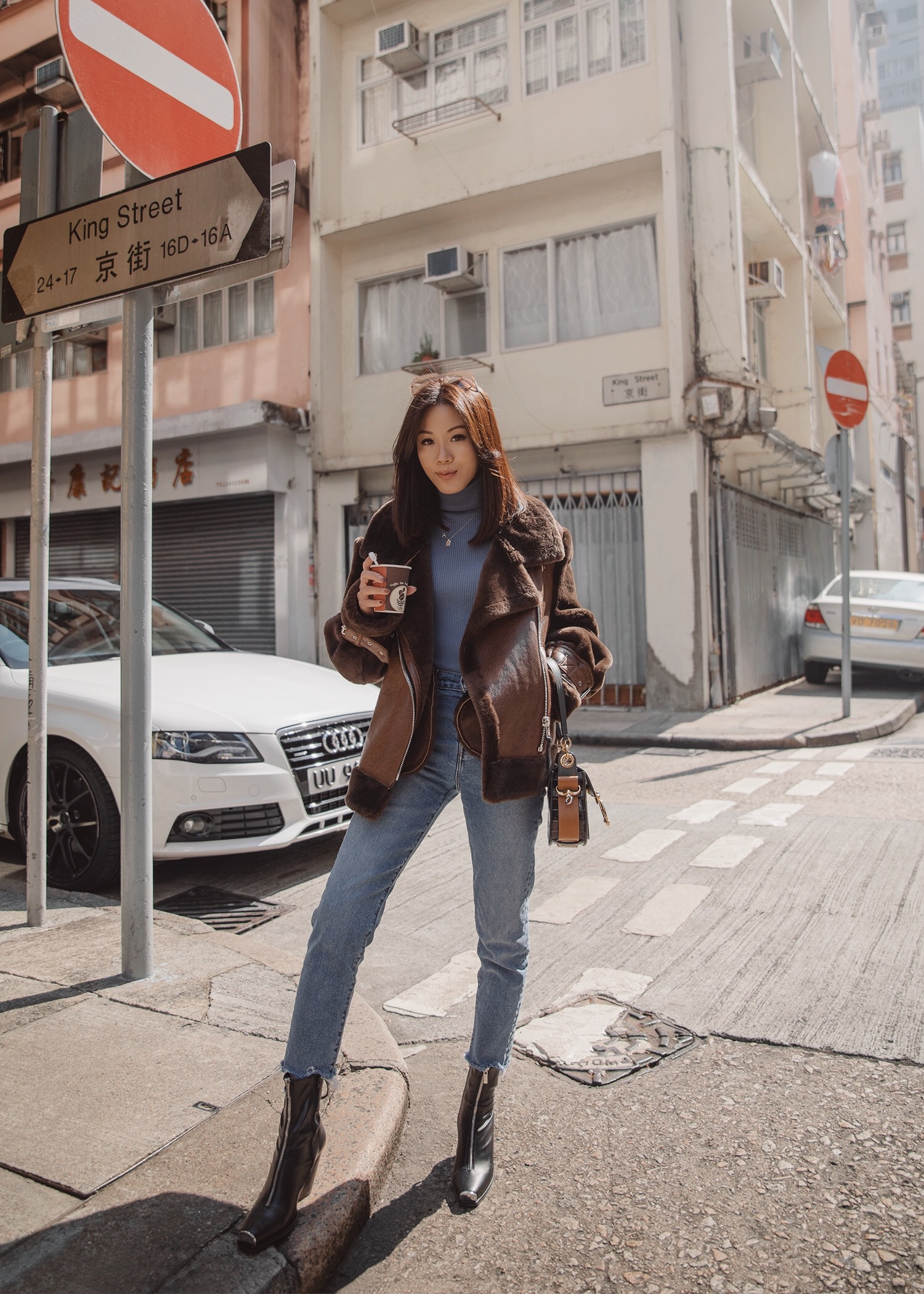 Jenny Tsang of Tsangtastic wearing nicole benisti teddy shearling jacket and levi's wedgie icon jeans in Hong Kong